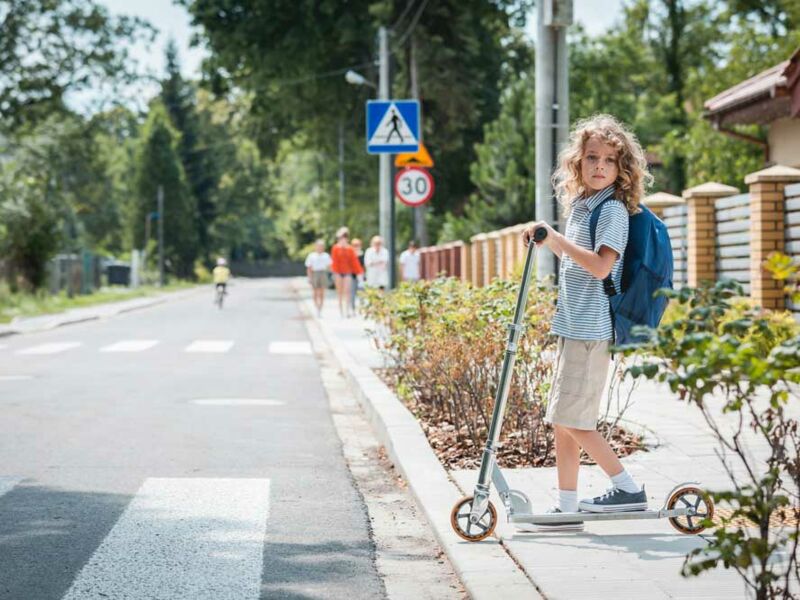 Symbolbild Kind wartet auf sichere Überquerung einer Straße
